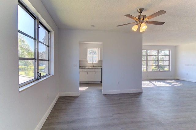 interior space with a textured ceiling, ceiling fan, and dark hardwood / wood-style flooring