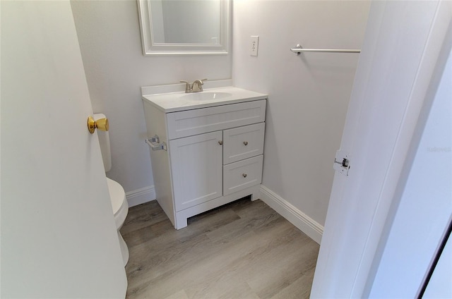 bathroom featuring toilet, hardwood / wood-style floors, and vanity