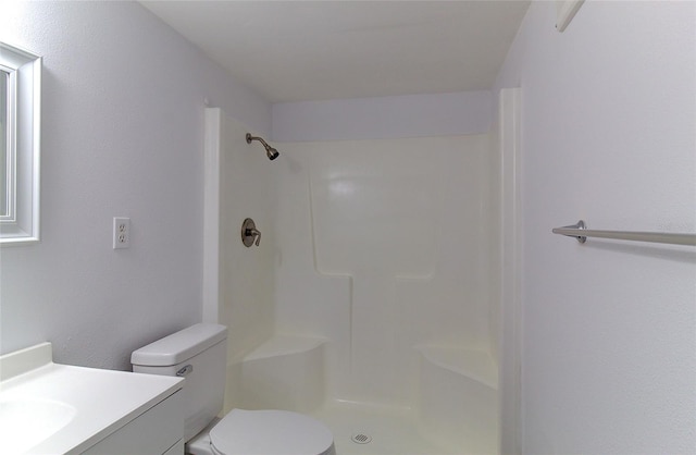 bathroom featuring vanity, a shower, and toilet