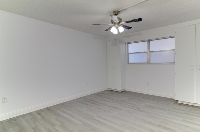 spare room featuring ceiling fan, light hardwood / wood-style flooring, and a textured ceiling