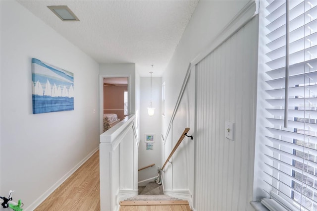 stairway featuring wood-type flooring and a textured ceiling