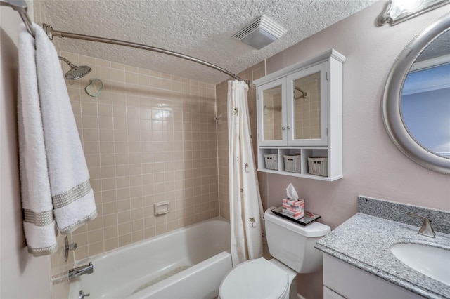 full bathroom with a textured ceiling, vanity, shower / bath combo with shower curtain, and toilet