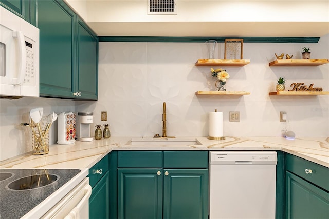 kitchen with sink, white appliances, light stone countertops, green cabinetry, and decorative backsplash