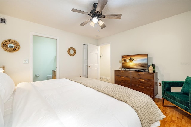 bedroom with hardwood / wood-style floors, ensuite bath, and ceiling fan