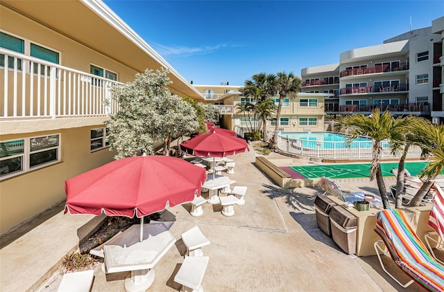 view of patio featuring a balcony and a community pool