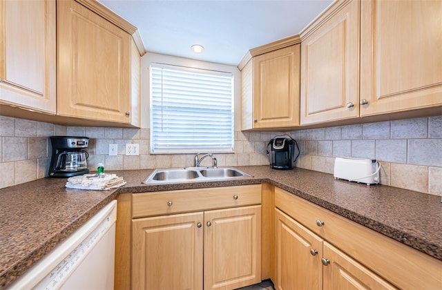 kitchen with light brown cabinetry, tasteful backsplash, sink, and dishwasher