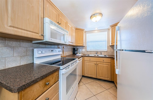 kitchen featuring white appliances, backsplash, sink, and light tile floors