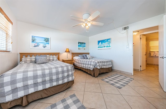 tiled bedroom featuring ceiling fan