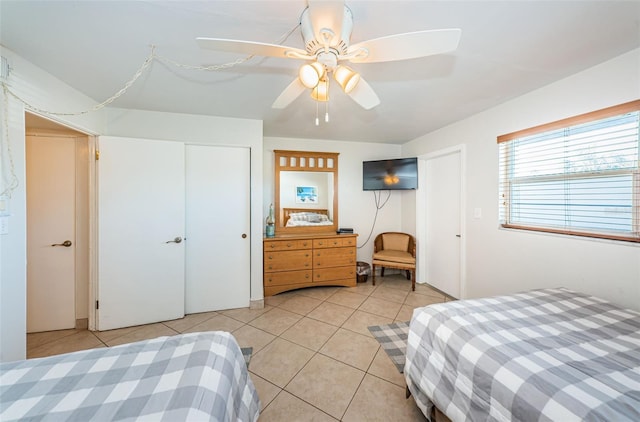 tiled bedroom featuring a closet and ceiling fan