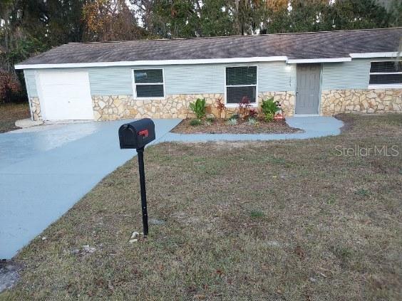 single story home featuring a front yard and a garage