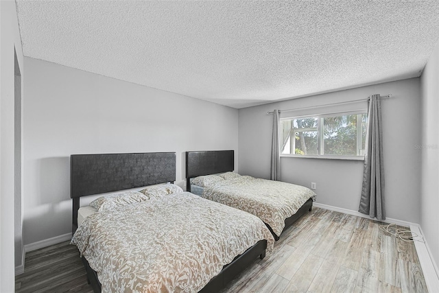 bedroom featuring a textured ceiling and hardwood / wood-style flooring