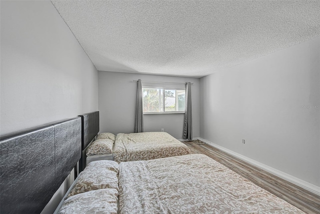 bedroom with dark wood-type flooring and a textured ceiling