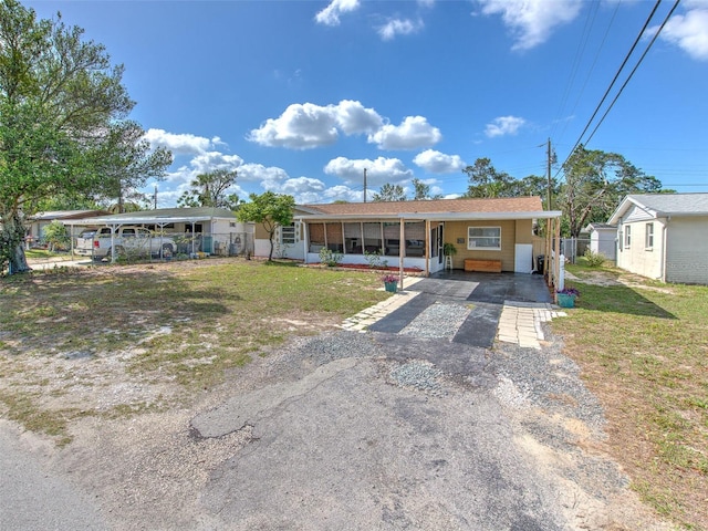 ranch-style home featuring a front yard and a carport