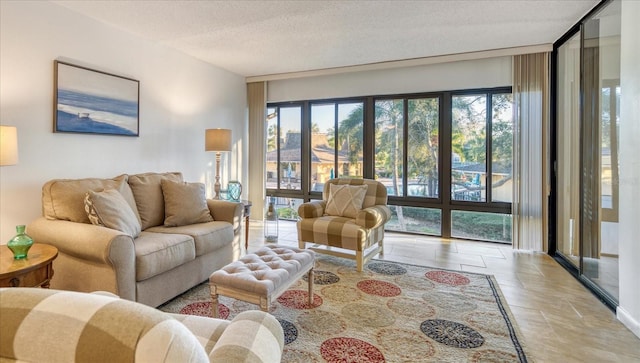 living room featuring a textured ceiling, expansive windows, a healthy amount of sunlight, and light tile flooring