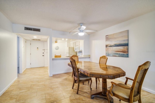 dining room featuring a textured ceiling, ceiling fan, and light tile floors