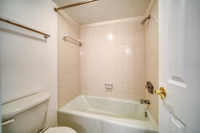 bathroom featuring tiled shower / bath combo and toilet