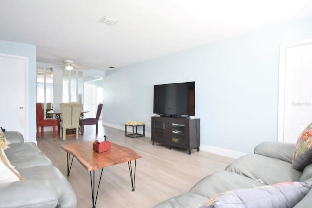 living room featuring ceiling fan and light hardwood / wood-style floors