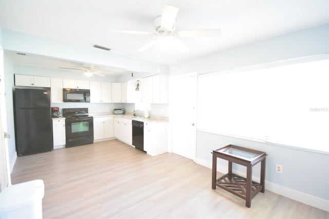 kitchen featuring sink, white cabinets, black appliances, and light hardwood / wood-style flooring