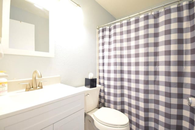 bathroom with curtained shower, toilet, and sink