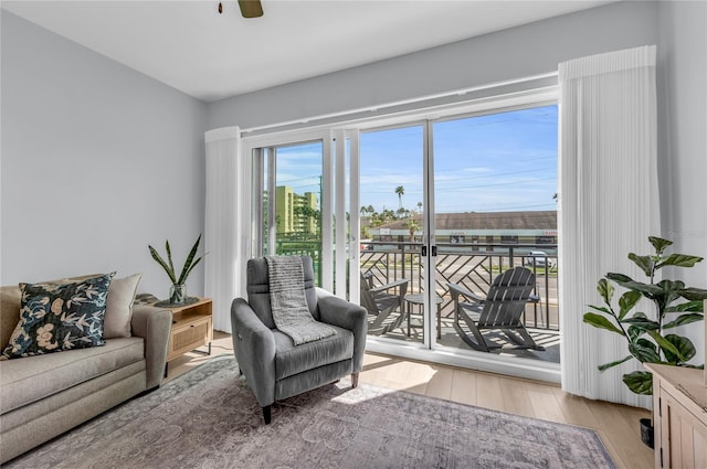 sitting room with light hardwood / wood-style floors and ceiling fan