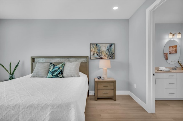 bedroom with light hardwood / wood-style floors and sink