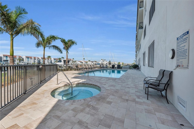 view of swimming pool with a community hot tub and a patio area