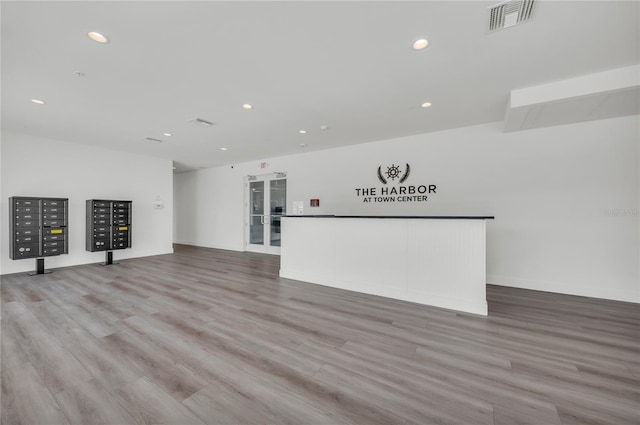 unfurnished living room with french doors, a mail area, and light hardwood / wood-style flooring