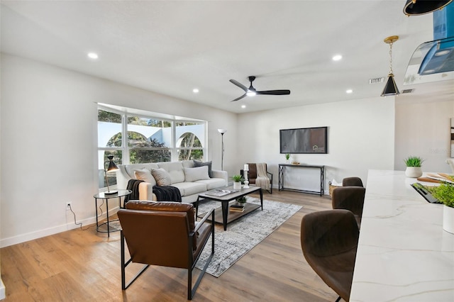 living room featuring light hardwood / wood-style flooring and ceiling fan