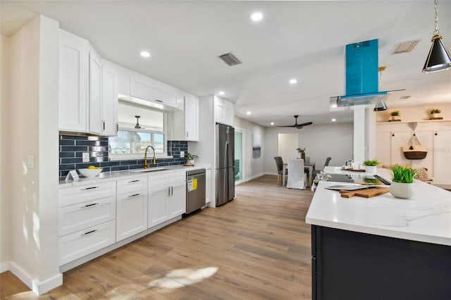 kitchen featuring ceiling fan, sink, stainless steel appliances, light hardwood / wood-style flooring, and white cabinets