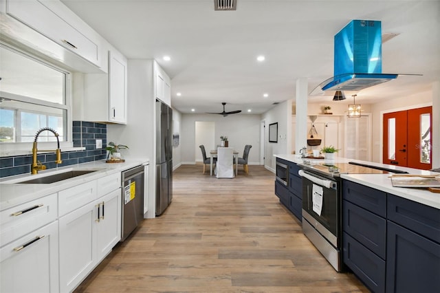 kitchen featuring sink, ceiling fan, appliances with stainless steel finishes, white cabinetry, and island exhaust hood