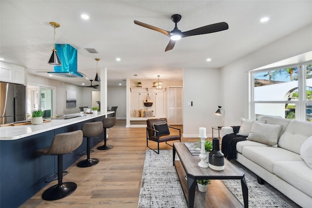 living room with ceiling fan and light wood-type flooring