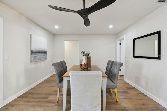 dining area with wood-type flooring and ceiling fan