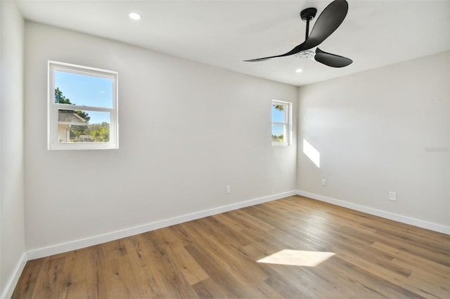 empty room featuring ceiling fan, a healthy amount of sunlight, and light wood-type flooring