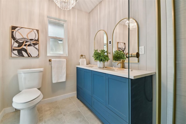 bathroom featuring tile patterned flooring, vanity, a chandelier, and toilet