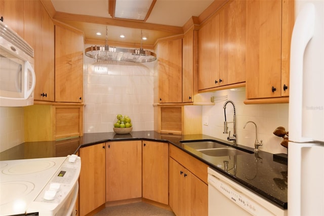 kitchen with backsplash, dark stone countertops, white appliances, and sink