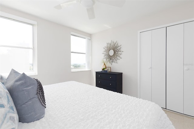 carpeted bedroom with a closet and ceiling fan