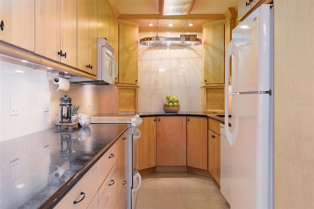 kitchen featuring backsplash, dark stone countertops, and white appliances