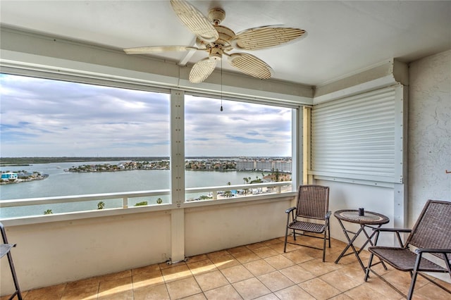 sunroom featuring a water view, a healthy amount of sunlight, and ceiling fan