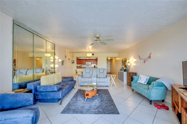 living room with a textured ceiling, light tile flooring, and ceiling fan