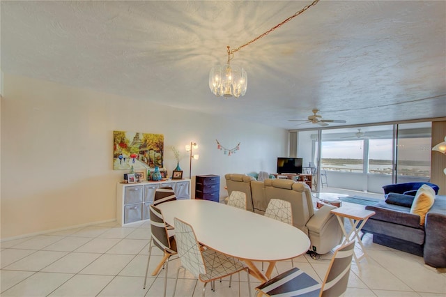 tiled dining room with a wall of windows, a textured ceiling, and ceiling fan with notable chandelier