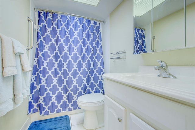 bathroom with toilet, tile floors, and vanity with extensive cabinet space