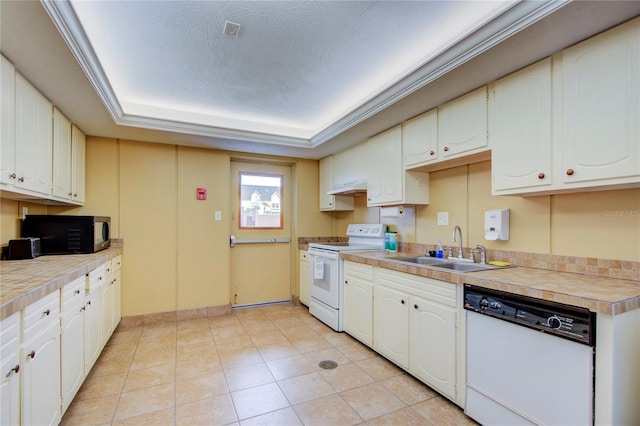 kitchen with a tray ceiling, light tile flooring, white appliances, sink, and white cabinets