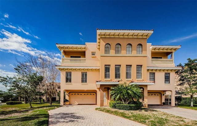 mediterranean / spanish-style house featuring a garage and a balcony