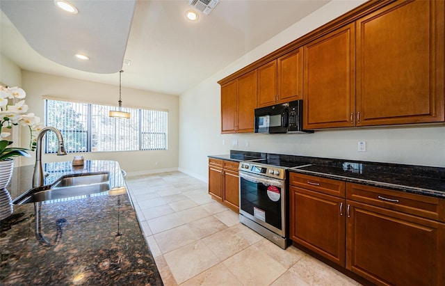 kitchen with dark stone counters, electric range, sink, and pendant lighting