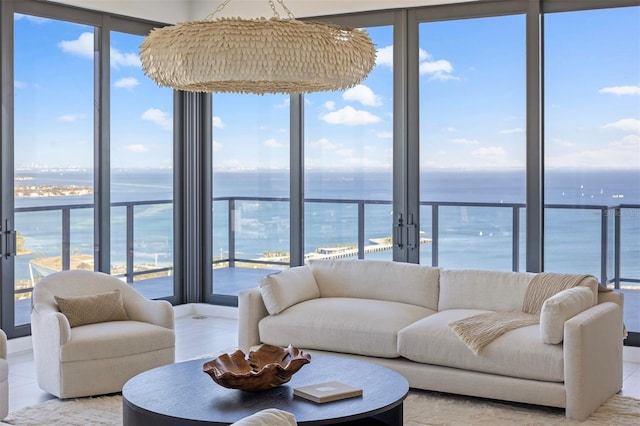 living room with plenty of natural light, french doors, and a water view