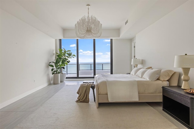 tiled bedroom featuring a water view, access to exterior, expansive windows, and a notable chandelier