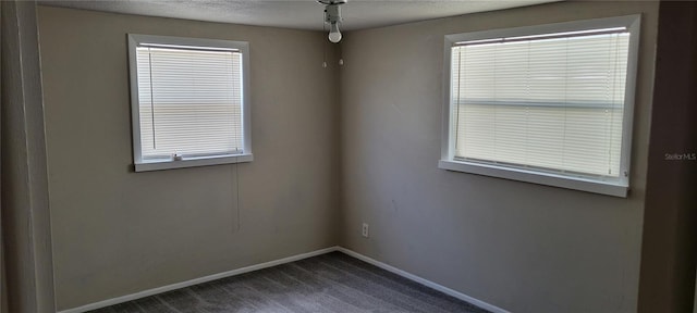 carpeted spare room with a textured ceiling