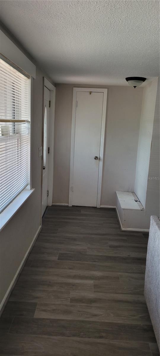 hall with dark hardwood / wood-style floors and a textured ceiling