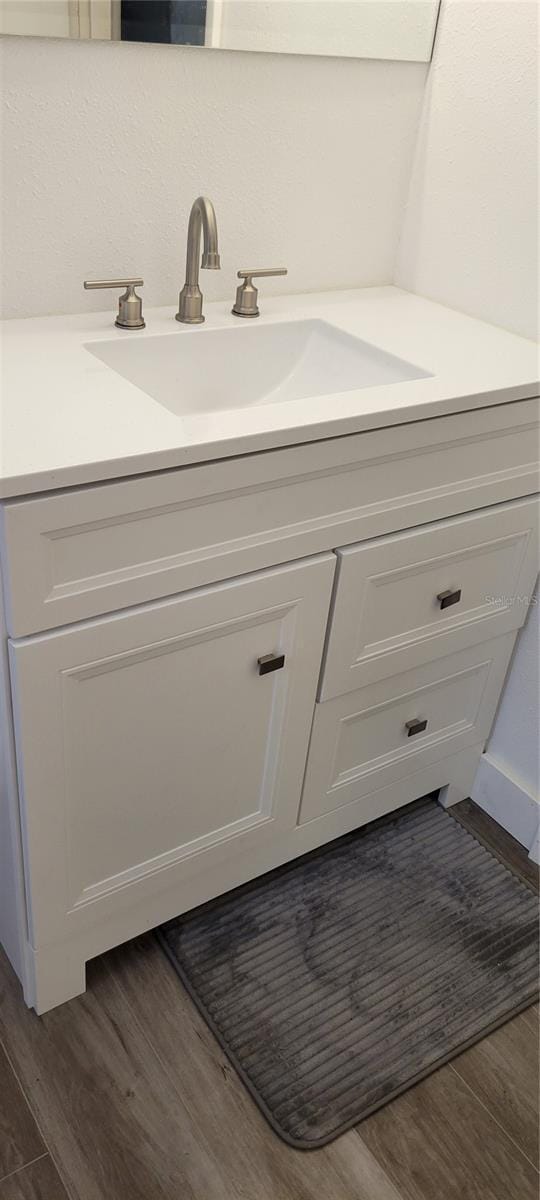 bathroom with vanity and hardwood / wood-style floors