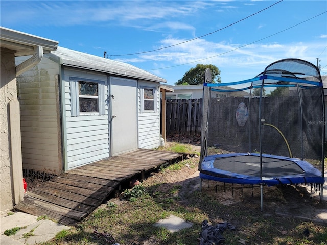 view of yard with a trampoline and a storage unit